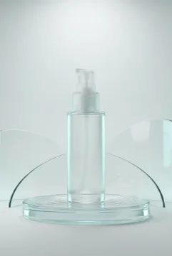 Translucent glass skincare serum bottle with frosted pump standing on a rippled glass pedestal in an aqua-lit 3D studio.